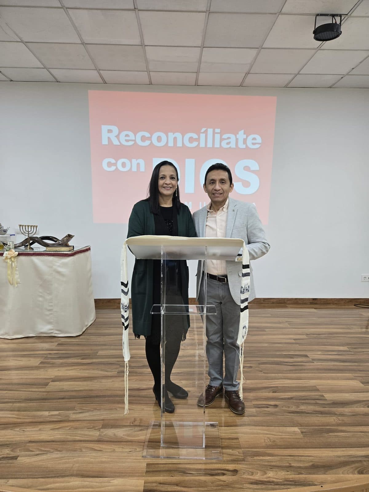 Dos personas dirigiendo el culto desde el púlpito de la iglesia de Albacete