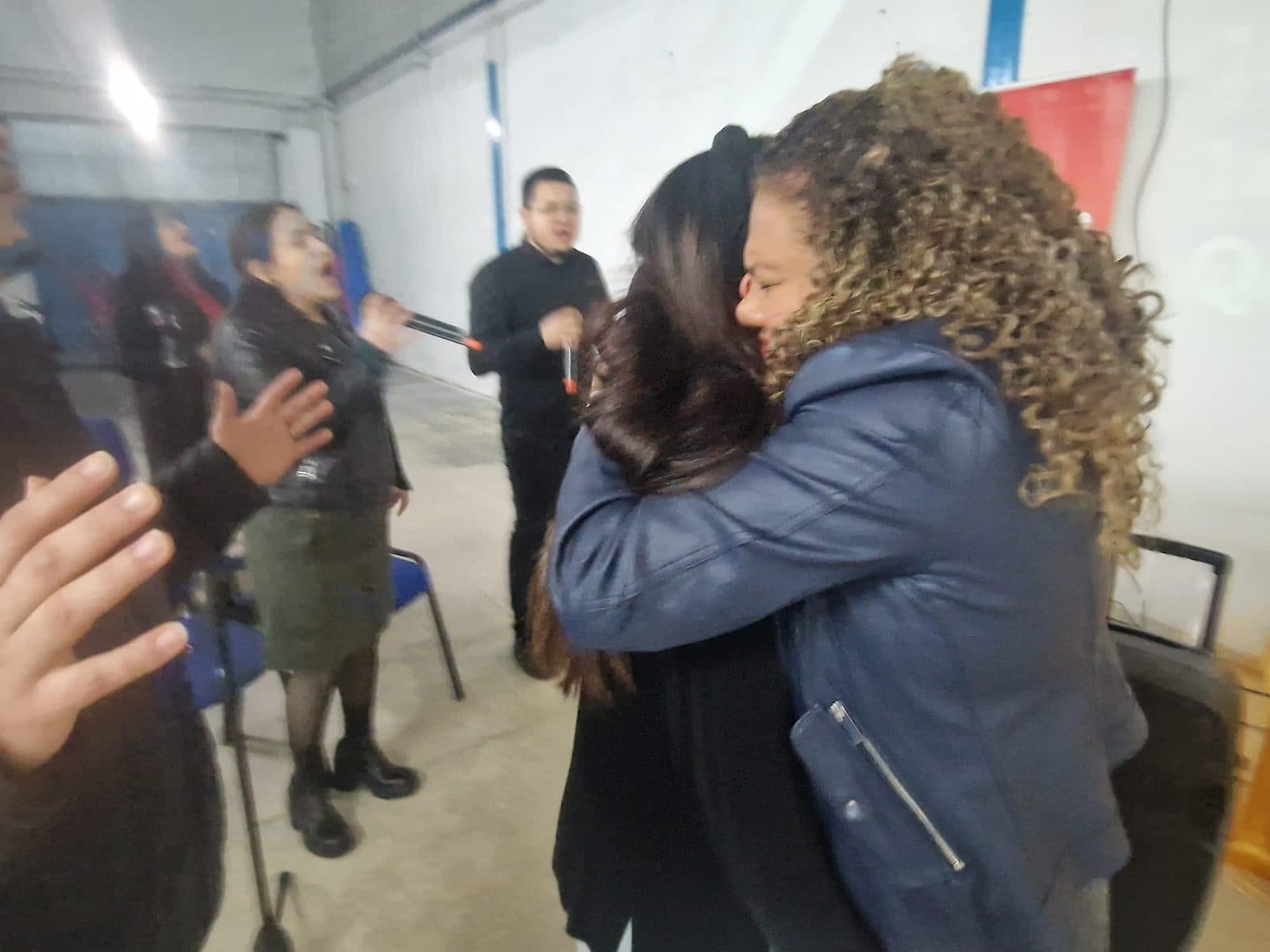 Dos personas abrazándose durante un encuentro en la iglesia de León