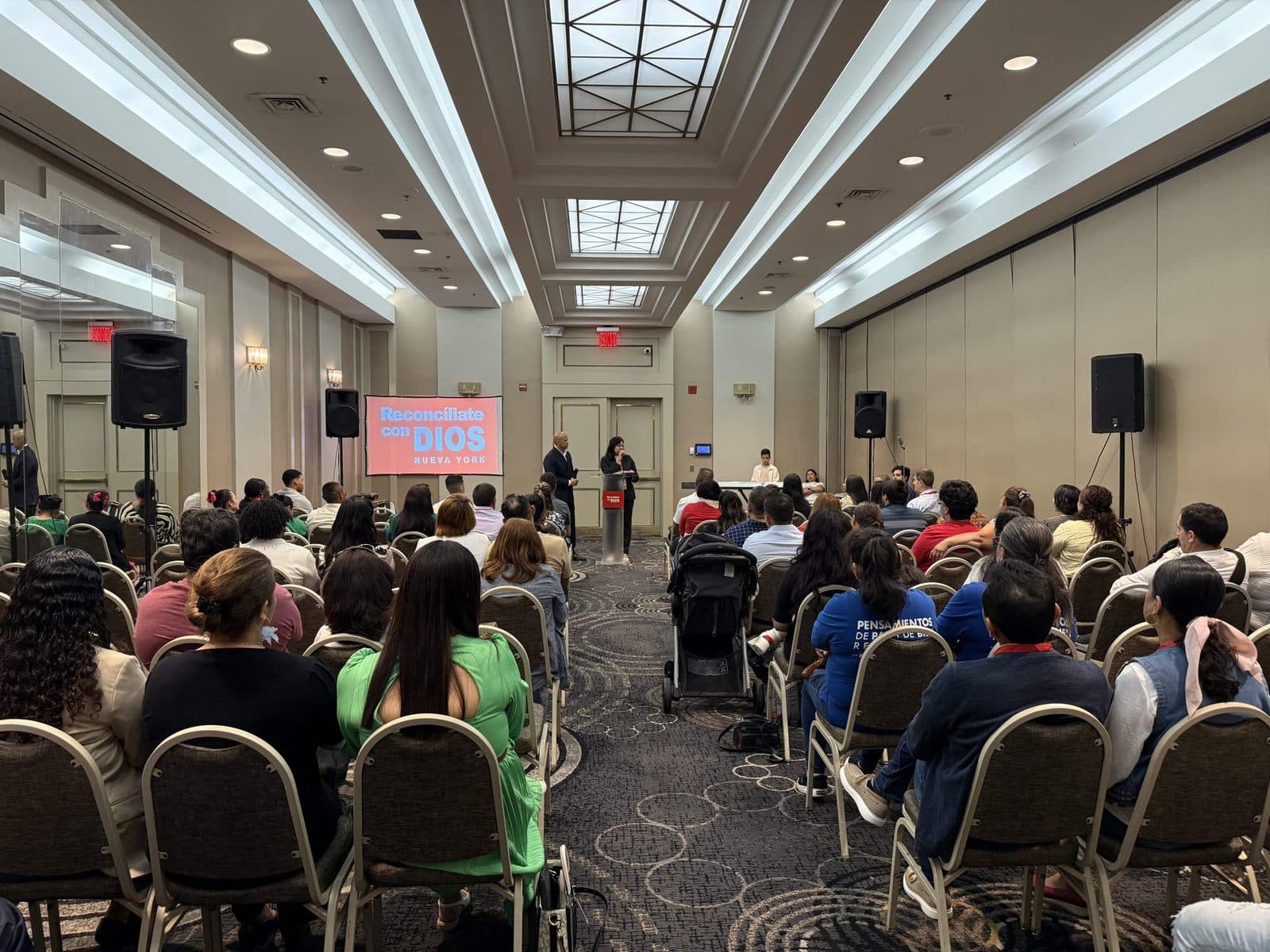 La congregación reunida en la sala de la iglesia de Queens